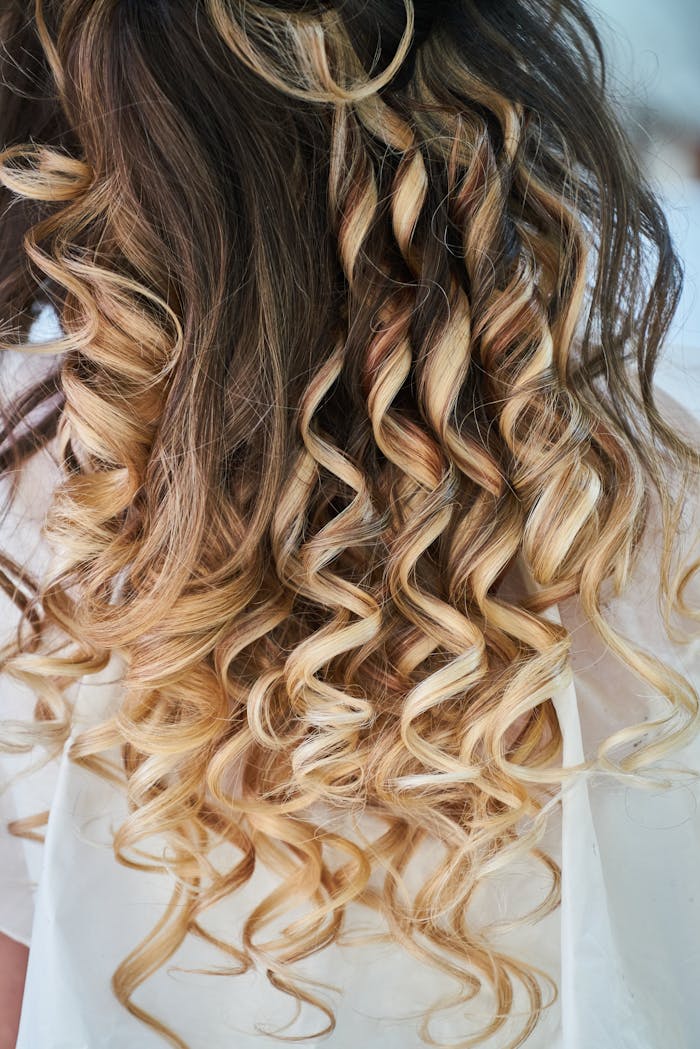 Close-up of elegant blonde curls showcasing detailed hairstyle design.